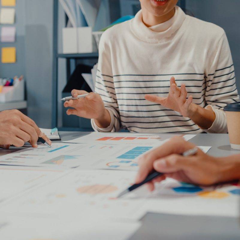 Happy young Asia businessmen and businesswomen meeting brainstorming some new ideas about project to his partner working together planning success strategy enjoy teamwork in small modern home office.